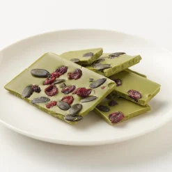 Chocolat blanc avec des canneberges sucrées, des graines de citrouille et du thé vert matcha